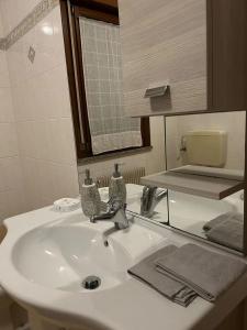 een badkamer met een wastafel met een spiegel en een wastafel bij Appartamento Elegante, Romantico e Riservato in Palazzolo dello Stella