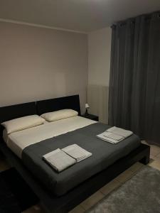 een slaapkamer met een groot bed en handdoeken bij Appartamento Elegante, Romantico e Riservato in Palazzolo dello Stella