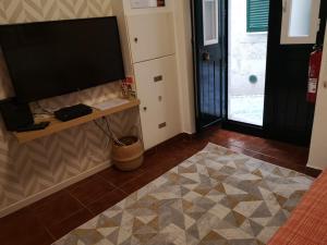 ein Wohnzimmer mit einem Flachbild-TV an der Wand in der Unterkunft Regueira Gold com terraço in Lissabon