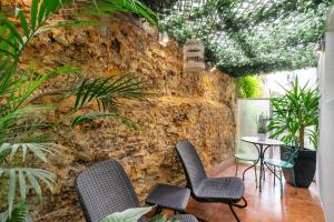 ein Zimmer mit Stühlen und einer Steinwand mit Pflanzen in der Unterkunft Regueira Gold com terraço in Lissabon