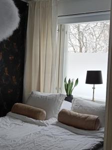 a bedroom with a bed with two pillows on it at Rauhallinen kaksio Urpolassa in Mikkeli