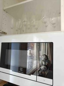 a row of wine glasses sitting on top of a microwave at Rauhallinen kaksio Urpolassa in Mikkeli