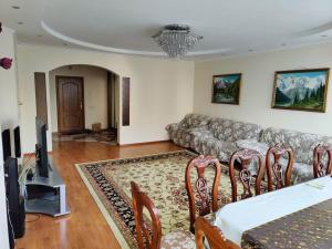 sala de estar con sofá, mesa y sillas en улица Гоголя 2 Апартаменты 180 метров en Almaty