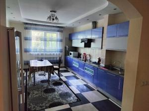 cocina con armarios azules y mesa en улица Гоголя 2 Апартаменты 180 метров en Almaty