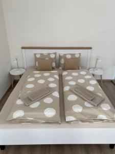 een bed met witte polka dot lakens en kussens bij LIA apartmán - PRIVATE PARKING in Bratislava