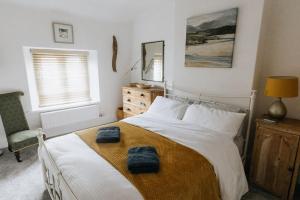 a bedroom with a bed with two towels on it at LITTLE BLUE HOUSE - Cottage with Seaview near the Lake District National Park in St Bees