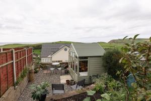 a small white house with a table and chairs at LITTLE BLUE HOUSE - Cottage with Seaview near the Lake District National Park in St Bees