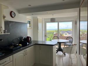 a kitchen with a table and a dining room with a view at LITTLE BLUE HOUSE - Cottage with Seaview near the Lake District National Park in St Bees +31 photos