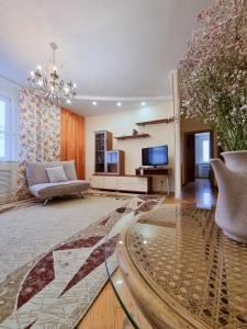 a living room with a couch and a tv at Квартира in Astana