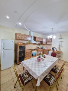 a kitchen with a table with chairs and a refrigerator at Квартира in Astana