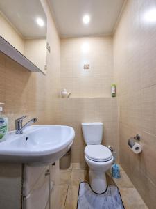 a bathroom with a white toilet and a sink at Квартира in Astana