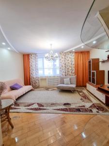 - un salon avec un canapé et un lustre dans l'établissement Квартира, à Astana