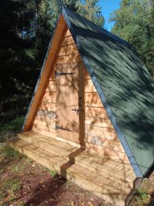 una caseta de madera con techo verde en Korjuse Moor en Korjuse