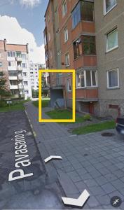 una scatola gialla su una strada di fronte a un edificio di Pavasario g. apartamentai a Mažeikiai