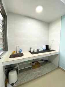 encimera con lavabo y aseo en Baiduri Homestay, en Kota Tinggi