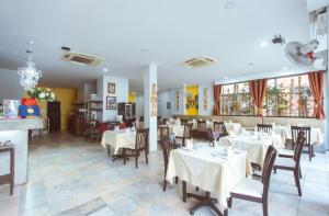 une salle à manger avec des tables et des chaises dans un restaurant dans l'établissement Istanbul Boutique Hotel, à Patong Beach
