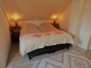 ein Schlafzimmer mit einem Bett mit zwei Lampen an zwei Tischen in der Unterkunft Gezellige vakantiewoning aan het water in Ewijk - recreational only no workers in Ewijk