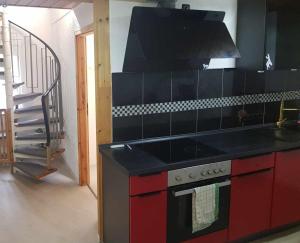 een keuken met een rode kachel en een trap bij Pension Giovanni in Cochem