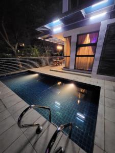 布城的住宿－OS Private Pool 3-Sty Bungalow Classic Elegant，夜间在房子前面的游泳池