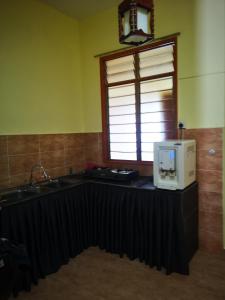 La cuisine est équipée d'un évier et d'un four micro-ondes. dans l'établissement Afwan homestay klebang melaka, à Malacca
