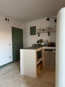 a kitchen with a white counter and a green door at La Petite Fenêtre in Casale Marittimo +15 photos