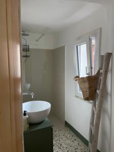 baño con bañera, lavabo y ventana en La Petite Fenêtre, en Casale Marittimo