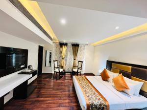 a hotel room with a bed and a flat screen tv at Hotel Aura IP Grand Karkardooma Metro Station New Delhi Couple friendly in New Delhi