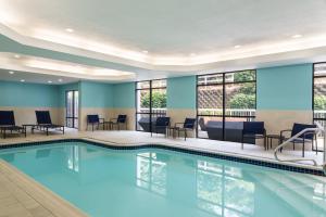 a pool in a hotel room with chairs and tables at SpringHill Suites West Mifflin in West Mifflin