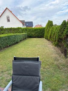 a chair sitting in a yard next to a hedge at Sternschnuppe in Borkum