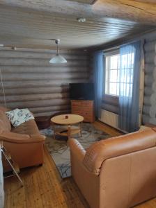 ein Wohnzimmer mit einem Sofa und einem Tisch in der Unterkunft Kalliorinteen Mökit Kalliopirtti in Töysä