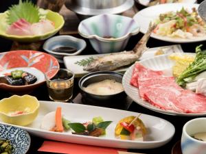 湯布院的住宿－Sanso Matsuya，一张桌子上放着许多盘子的食物