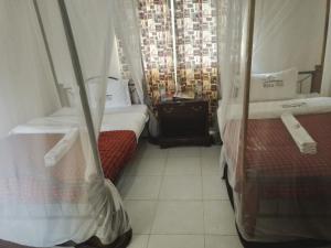 - une chambre avec 2 lits et une fenêtre dans l'établissement Kivu Resort, à Nakuru