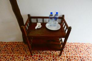 a wooden chair with two bottles of water on a plate at Ao Yai Homestay in Ban Ao Yai
