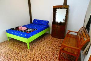 um pequeno quarto com uma cama e uma cadeira em Ao Yai Homestay em Ban Ao Yai