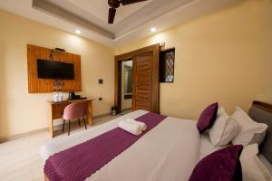 a bedroom with a large bed and a desk at PerfectPlus Mussoorie in Mussoorie