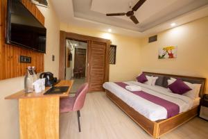 a bedroom with a bed and a desk in a room at PerfectPlus Mussoorie in Mussoorie