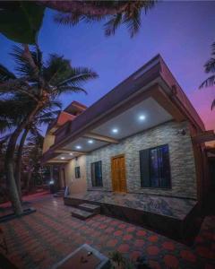 una casa con palmeras delante en Indira Homestay en Mangalore
