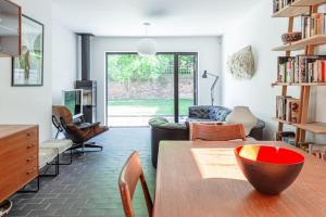sala de estar con mesa y sala de estar con sofá en Gorgeous 1BD Balearic-style home with Gardens en Cheltenham