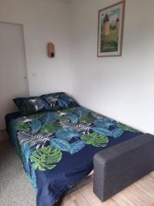 1 dormitorio con 1 cama con edredón azul en Mon Alouette - Gîte & Bien-Être, en Les Herbiers