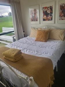 Schlafzimmer mit einem großen Bett und einem Fenster in der Unterkunft Tui Cottage 