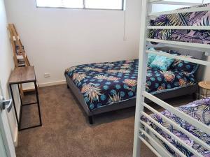 a bedroom with a bunk bed and a ladder to a bed at Coastal Palms - relax by the golf course in Normanville