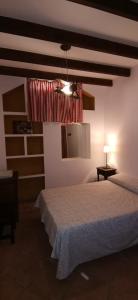 a bedroom with a bed and a window and a lamp at Huerta Solana in Castril +13 photos