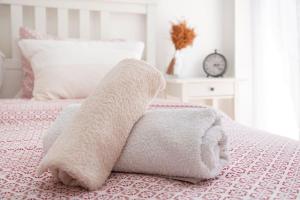 - une serviette blanche sur le lit dans l'établissement Cosy Apartment With Acropolis View, à Athènes