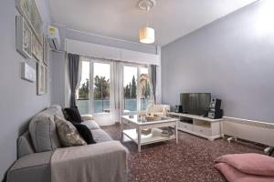 Cosy Apartment With Acropolis View في أثينا: غرفة معيشة مع أريكة وتلفزيون
