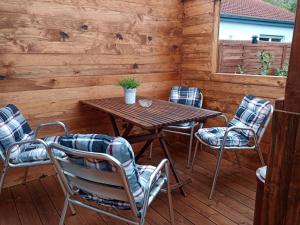 a wooden table and chairs on a wooden deck at Ferienwohnung Rose in Glan-Münchweiler