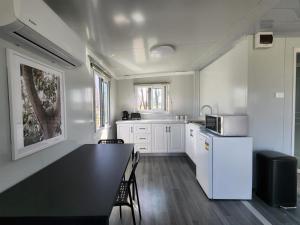 a kitchen with a black table and a white refrigerator at Moruya Motel in Moruya
