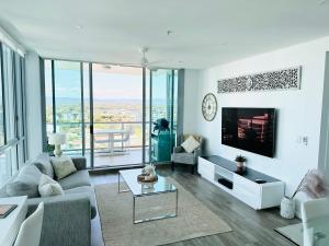 uma sala de estar com um sofá e uma televisão em Modern Gold Coast Apartment with great Amenities em Gold Coast