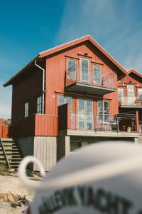 a wooden house with a porch and a balcony at Hotel Strana in Hälleviksstrand