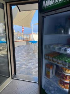 a refrigerator with its door open next to a patio at La Ruota B&B in Terrasini