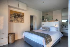 a bedroom with a bed and a picture of a car on the wall at The SunCatcher in Cape Town +30 photos